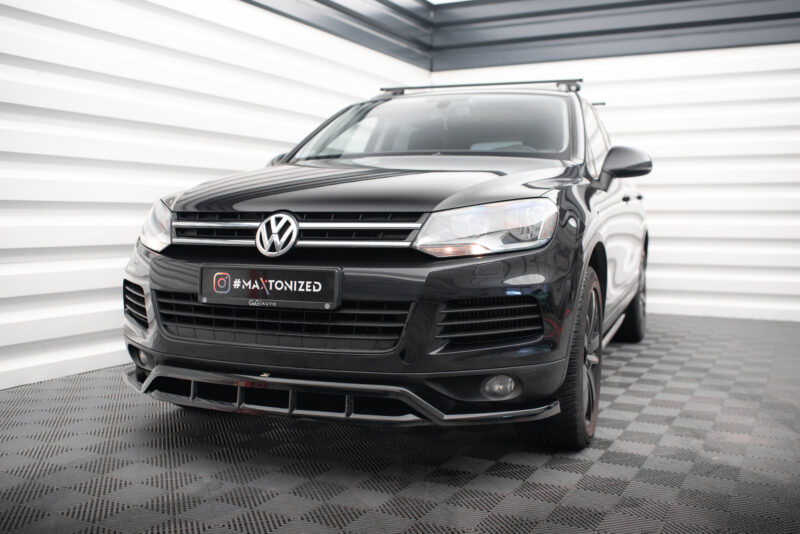 Front three-quarter view of a black Volkswagen SUV in a bright studio, chrome grille, and a '#MAXTONIZED' license plate visible at the front.