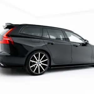 Rear three-quarter view of a black SUV with red taillights, large alloy wheels, and a sporty spoiler.