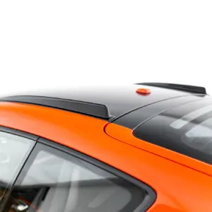 Close-up of an orange car roof with a black panoramic panel and small orange roof antenna, showing roof rails and curved windshield edges.