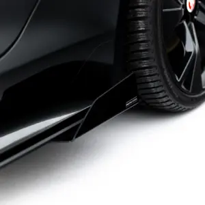 Close-up of a black car's wheel and tire, reflecting the glossy body panel.