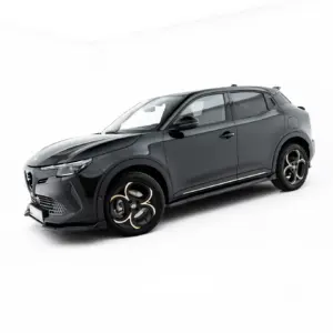 Dark gray SUV photographed in a studio with large black and gold alloy wheels against a white background, angled from the front side view, low perspective.