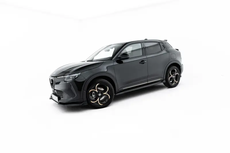 Dark gray SUV photographed in a studio with large black and gold alloy wheels against a white background, angled from the front side view, low perspective.
