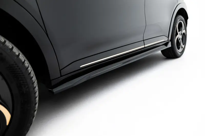 Close-up of a dark gray SUV side showing a chrome running board and wheel.