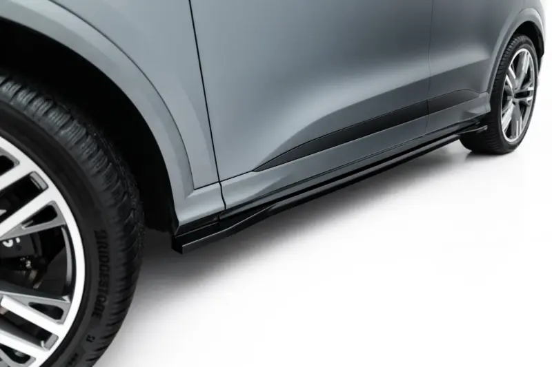 Side view of a metallic gray car body with a prominent wheel and quarter panel visible on a clean white background