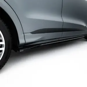 Close-up of a gray car's side panel and alloy wheel, showing smooth curves and a black trim along the door.
