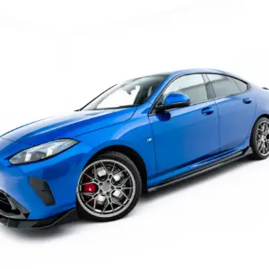 Blue BMW M sports car viewed from the front-left, showcasing its angular headlights, grille, and large multi-spoke alloy wheels.