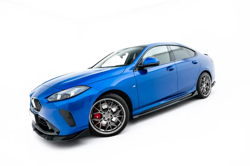 pol_po_Side-Skirts-Diffusers-BMW-2-M235i-Gran-Coupe-M-Pack-F74-23854_5webp - OPSHOLDERS Blue BMW M sports car viewed from the front-left, showcasing its angular headlights, grille, and large multi-spoke alloy wheels.