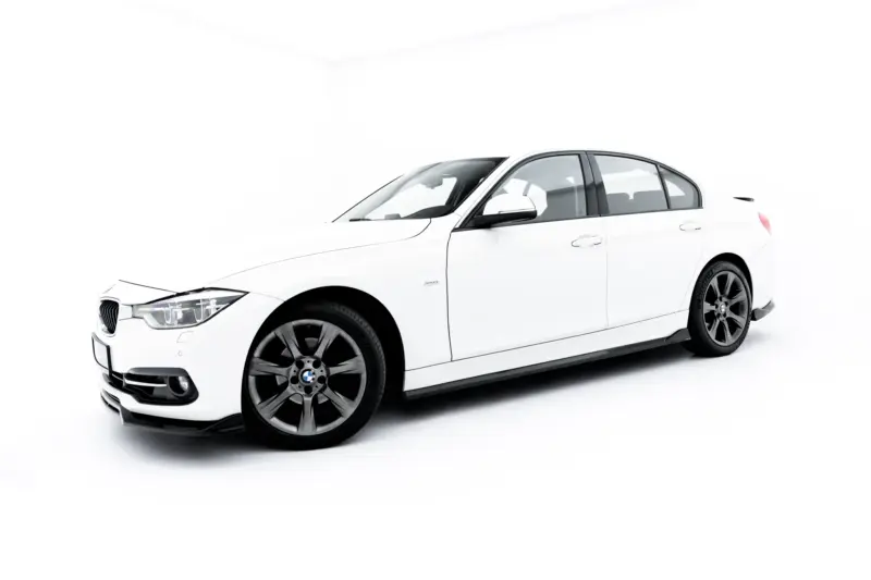 White BMW sedan shown from a low front-left angle in a bright studio setting, with visible front grille and wheels.