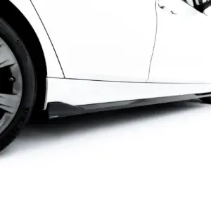 Close-up of a white BMW car’s front wheel and lower body panel, showing alloy wheel and tire detail.