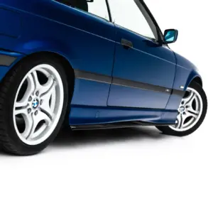 Blue BMW sedan shown from a low, angled side view focusing on the front wheel and door panel.