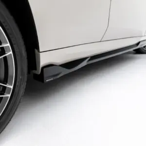 Close-up of a white car's side skirt and large multi-spoke alloy wheel.
