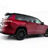 pol_po_Side-Skirts-Diffusers-Jeep-Grand-Cherokee-L-Mk5-23902_1webp - OPSHOLDERS Red Jeep Grand Cherokee SUV shown from the rear-left side in a bright studio setting, highlighting the spoiler and black wheels.