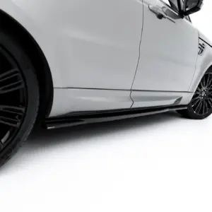 Close-up of a white car's side, featuring black alloy wheels and sleek body lines against a white background.