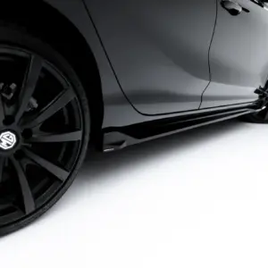 Close-up of a gray car body and black alloy wheel against a white studio background. The image highlights the wheel and sleek panel lines without background clutter.