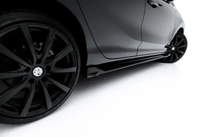 Close-up of a gray car body and black alloy wheel against a white studio background. The image highlights the wheel and sleek panel lines without background clutter.