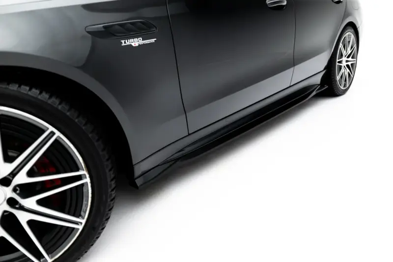 pol_po_Side-Skirts-Diffusers-Mercedes-AMG-C63-Sedan-Estate-W206-S206-23827_5webp - OPSHOLDERS Close-up of a gray car's side with a Turbo Performance badge and large alloy wheel visible by the front fender.