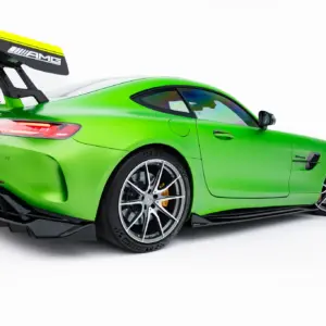 Green sports car with a large rear wing, glossy lime paint, and sporty wheels, shown from the back-left side against a white background.