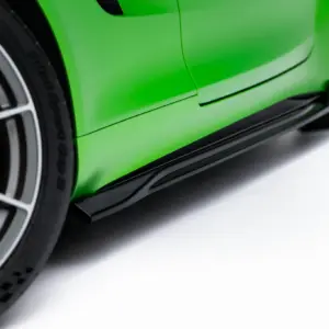 Close-up of a bright green sports car wheel with an orange brake caliper behind it.
