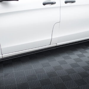 Side view of a white SUV showing mid doors, door handles, and a running board along a textured gray floor contrast.