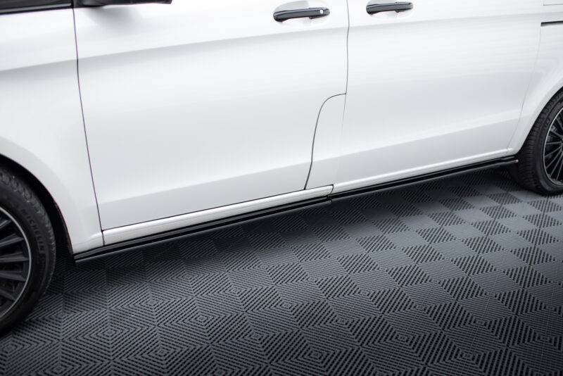 Side view of a white SUV showing mid doors, door handles, and a running board along a textured gray floor contrast.