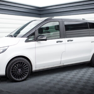 Side view of a white van with black trim, tinted windows, and large black multi-spoke wheels indoors on a checkered floor.