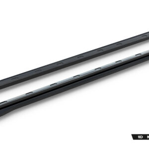 Pair of black car side skirts with mounting clips laid diagonally on a white background, Maxton Design product shot