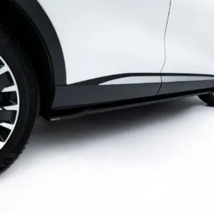 Close-up of a white car's wheel and lower body panel with a black multi-spoke alloy rim.