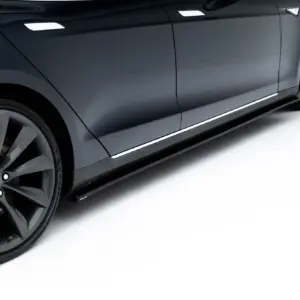 Close-up of a dark gray car's side panel and large alloy wheel, showing reflections along the door and chrome trim.