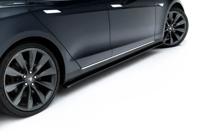 pol_po_Side-Skirts-Diffusers-V-1-Tesla-Model-S-Mk1-23946_4webp - OPSHOLDERS Close-up of a dark gray car's side panel and large alloy wheel, showing reflections along the door and chrome trim.