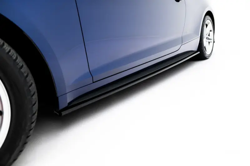 Close-up of a blue car's side panel and wheel against a white background, showing the rocker area and door seam.