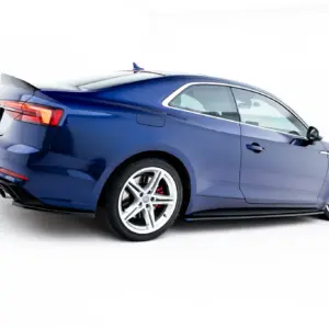 Blue sport coupe photographed from the rear-left angle, showing a spoiler and sporty wheels against a white background, emphasizing design.