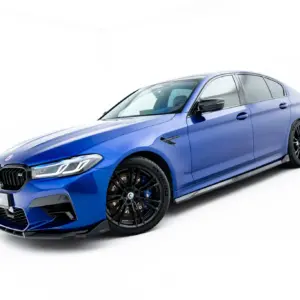 Blue luxury sedan shown from a low front-left angle, highlighting the grille and black alloy wheels.