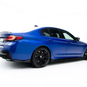 Blue BMW M-model viewed from the rear-right side on a white studio background.