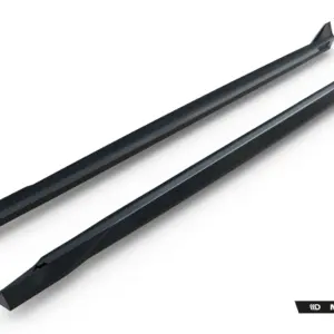 Two black glossy car side skirts photographed diagonally on a white background, with the Maxton Design logo visible in the corner.