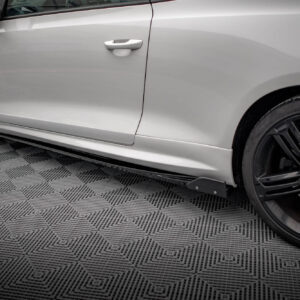 Side view of a silver car showing the front door, door handle, and black alloy wheels on a textured showroom floor.