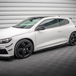White sports car parked indoors against a striped wall with dark alloy wheels on a checkered floor.