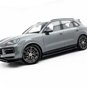 Three-quarter front view of a silver Porsche SUV with large black alloy wheels and glossy finish.