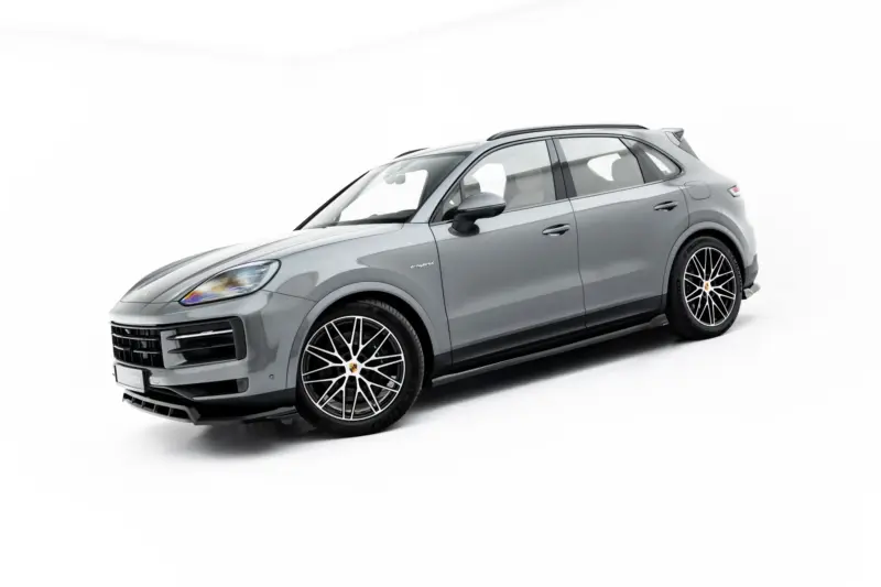 Three-quarter front view of a silver Porsche SUV with large black alloy wheels and glossy finish.
