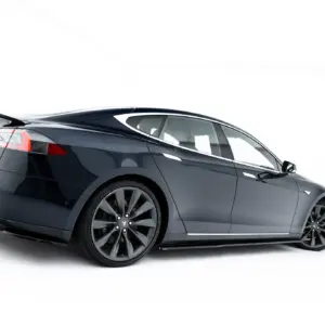 Rear three-quarter view of a dark gray Tesla Model S on a white background behind white space.