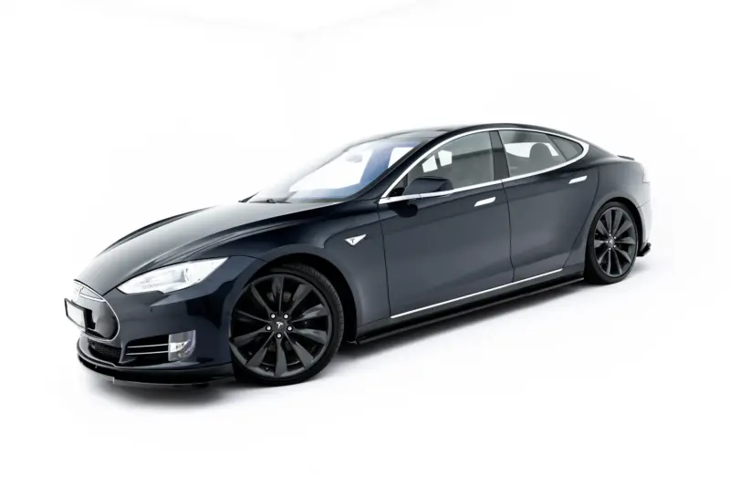 Dark blue Tesla electric sedan shown from a low front-left angle, highlighting the sleek body and large wheels on a white backdrop.
