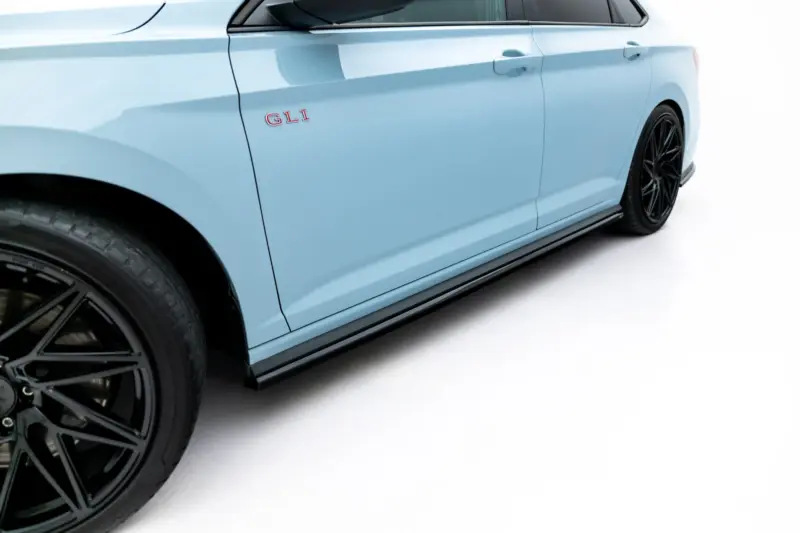 Side view of a light blue car door with a red GLI badge and black alloy wheels visible at the front wheel well.