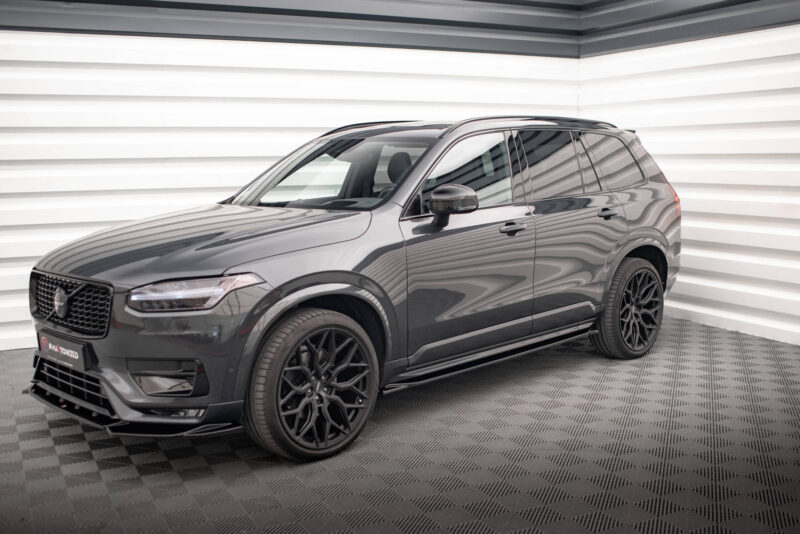 Dark gray SUV shown from the front-right side in a showroom, with glossy finish and large black alloy wheels.