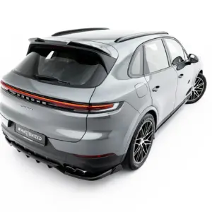 Rear three-quarter view of a silver Porsche Cayenne SUV with black roof rails and stylish alloy wheels on a white background.