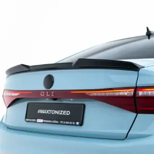 Rear of a light blue Volkswagen hatchback with GLI badge, VW emblem, and red taillights; license plate reads #MAXTONIZED.