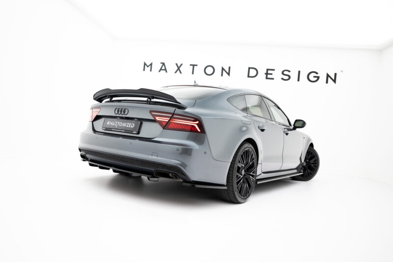 Gray Audi with a rear spoiler in a bright white showroom, Maxton Design branding on the wall behind.