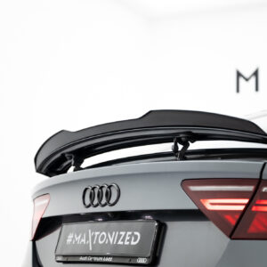 Rear view of a silver Audi SUV with the trunk open, showing red taillights and a license plate area reading '#MAJTONIZED' and 'Audi Centrum Łódź' in the bottom frame.
