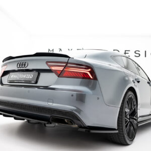 Rear three-quarter view of a silver Audi sedan in a bright white studio, showing taillights and large alloy wheels.