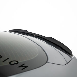 Close-up of a car roof edge with a black roof rail over a curved windshield against a white background.