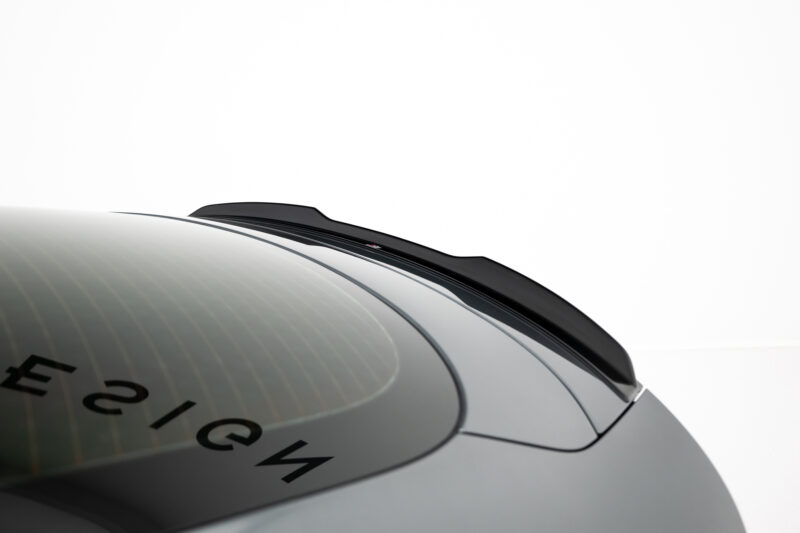 Close-up of a car roof edge with a black roof rail over a curved windshield against a white background.