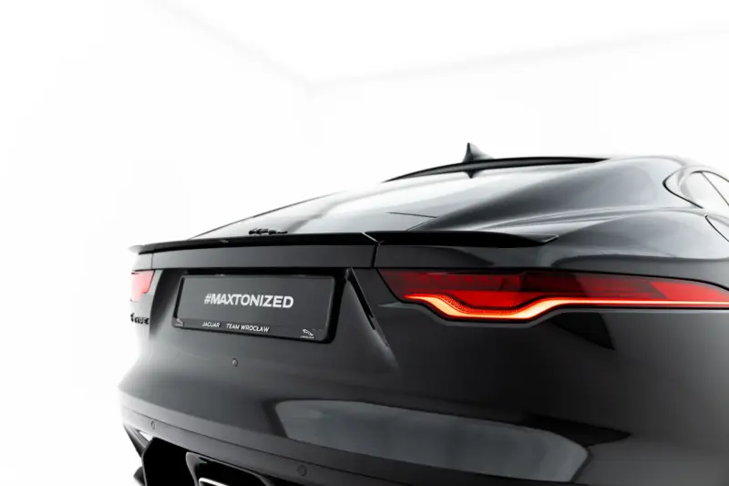 pol_po_Spoiler-Cap-Jaguar-F-Type-X152-Facelift-2-23971_10webp - OPSHOLDERS Rear view of a dark Jaguar with illuminated taillights and a visible #MAXTONIZED license plate area.
